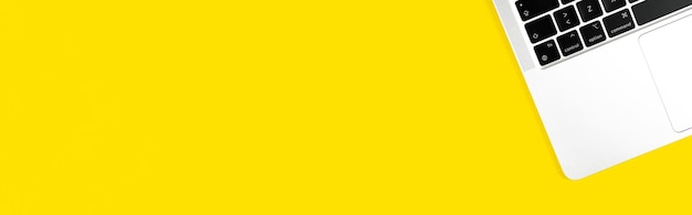 Sfondo di banner giallo piatto moderno laptop. Tastiera per notebook. Tavolo da lavoro per ufficio, concetto di design minimale. Vista dall'alto, copia la foto dello spazio