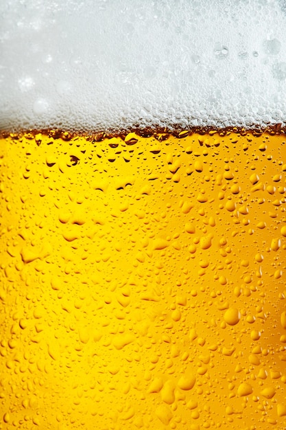 Sfondo di birra con schiuma di schiuma a bolle che versa soda alcolica in vetro