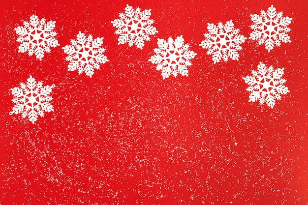 Sfondo di buon Natale e felice anno nuovo con fiocchi di neve su rosso lucido