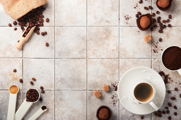 Sfondo di caffè Misurini con tazza di chicchi di caffè macinato e tartufi di cioccolato dolce su sfondo vecchio tavolo incrinato piastrella Sfondo alimentare Vista dall'alto con spazio per il testo