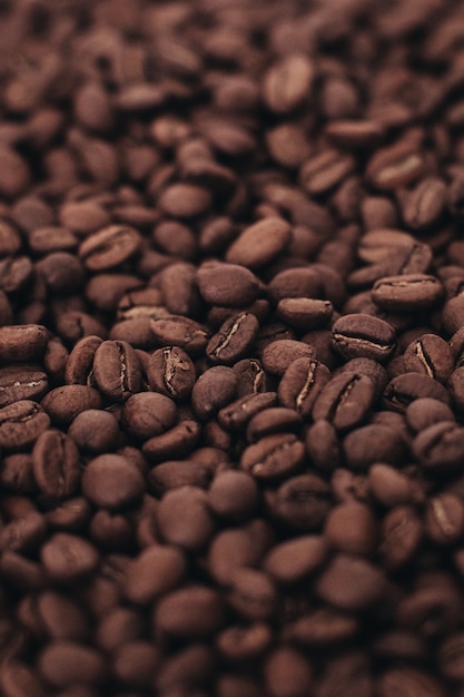 Sfondo di chicchi di caffè marrone scuro aromatico Vista dall'alto foto verticale con effetto grana della pellicola