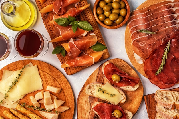 Sfondo di cibo italiano con prosciutto, formaggio, olive, pane e vino