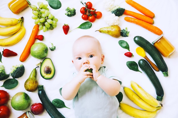 Sfondo di cibo sano per la nutrizione del bambino Bambino sorridente di 8 mesiPrima alimentazione solida del bambino
