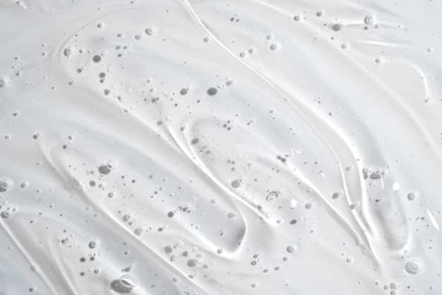 Sfondo di crema per la cura della pelle liquida con texture di siero in gel trasparente