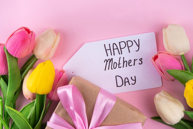 Sfondo di festa della madre con scatola regalo di fiori e tag Happy Mother's Day