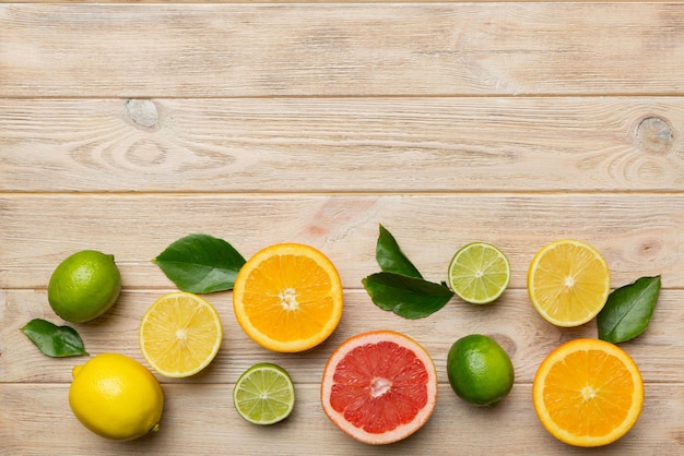 Sfondo di frutta Frutta fresca colorata su tavola colorata Pompelmo arancione limone Spazio per il concetto sano di testo Spazio per la copia della vista dall'alto piatto