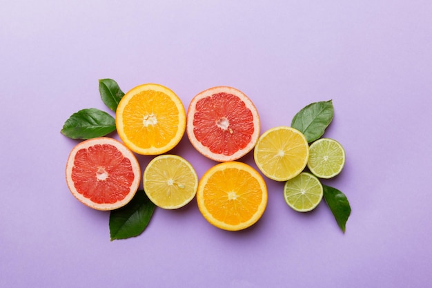 Sfondo di frutta Frutta fresca colorata su tavola colorata Pompelmo arancione limone Spazio per il concetto sano di testo Spazio per la copia della vista dall'alto piatto