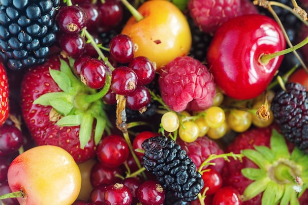 Sfondo di frutti di bosco fragola fragola, lampone, mora, ribes rosso e giallo, ciliegie.