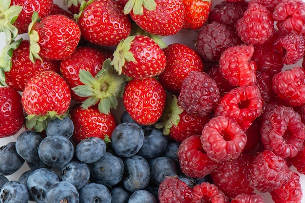 Sfondo di frutti di bosco freschi e gustosi Fragole, mirtilli e lamponi si chiudono sulla vista dall'alto