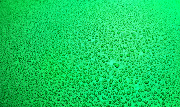 Sfondo di goccia d'acqua. gocce di pioggia sulla superficie di metallo verde