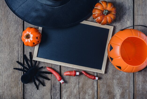 Sfondo di Halloween con zucche, cappello di strega, ragno nero, dita e lavagna