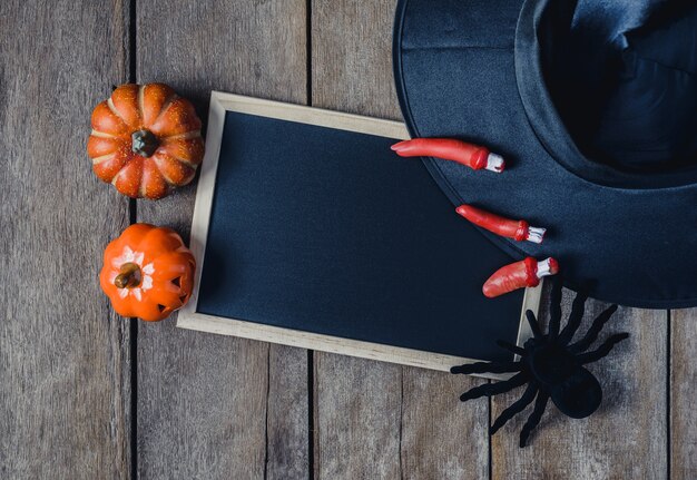 Sfondo di Halloween con zucche, cappello di strega, ragno nero, dita e lavagna