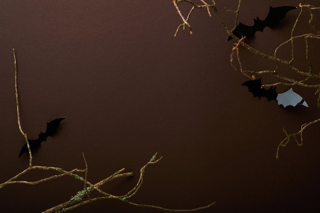 Sfondo di Halloween Stormo di pipistrelli neri scheletro di zucca ragno e foglie per Halloween Sagome di pipistrelli di carta nera su sfondo marrone o scuro Decorazione autunnale Concetto di Halloween Vista dall'alto