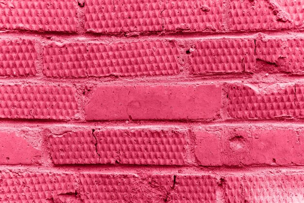 Sfondo di mattoni in rilievo con texture rosa invecchiato vecchio muro di pietra o blocchi di trama stradale sullo sfondo modello di primo piano architettura costruzione design tonica in viva magenta colore di tendenza dell'anno 2023