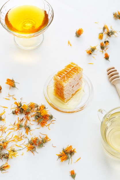 Sfondo di miele Favi, miele dolce e fiori di calendula sul tavolo.