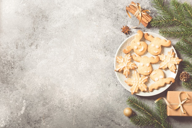 Sfondo di natale. composizione in natale con rami di abete, regali, dolci, biscotti, cannella su uno sfondo di cemento chiaro