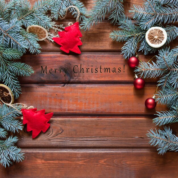 Sfondo di Natale con abete e decorazione su tavola di legno scuro