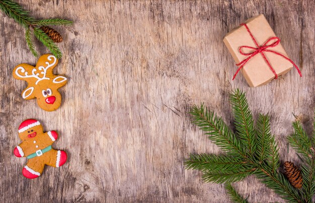 Sfondo di Natale con albero di abete, pan di zenzero e una confezione regalo