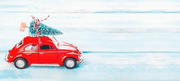 Sfondo di Natale con auto rossa e albero di Natale