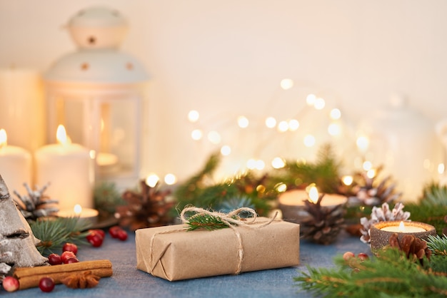 Sfondo di Natale con confezione regalo e decorazioni, candele e ghirlande di luci. Felice anno nuovo