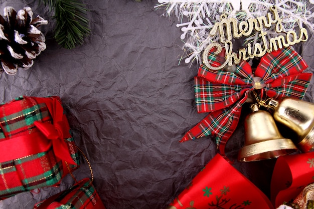 Sfondo di Natale con decorazioni e scatole regalo su sfondo grigio scuro.