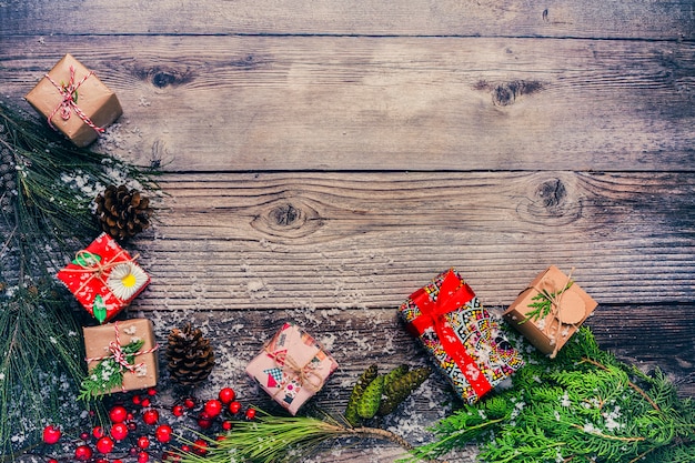 Sfondo di Natale con decorazioni e scatole regalo sul bordo di legno.