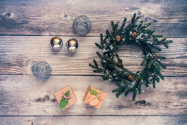 Sfondo di Natale con decorazioni e scatole regalo sul bordo di legno.