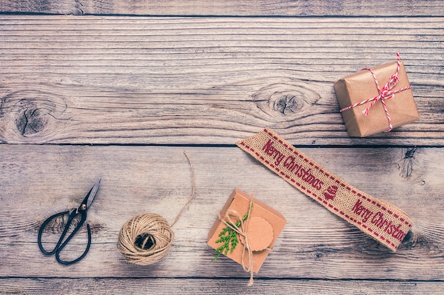 Sfondo di Natale con decorazioni e scatole regalo sul bordo di legno.