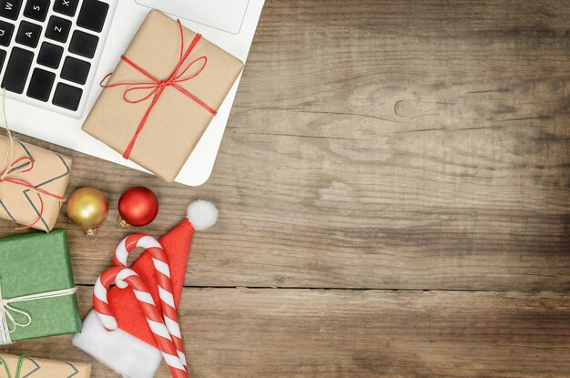 Sfondo di Natale con laptop, scatole regalo e decorazioni