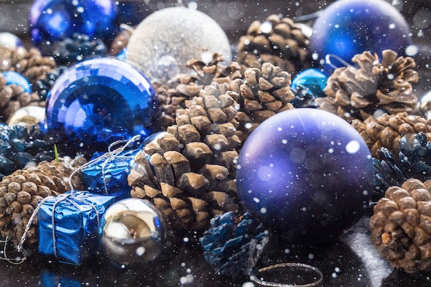 Sfondo di Natale con palline e pigne d'argento blu.