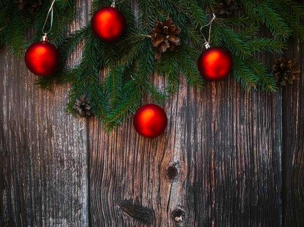 Sfondo di Natale con palline rosse, rami di abete e pigne