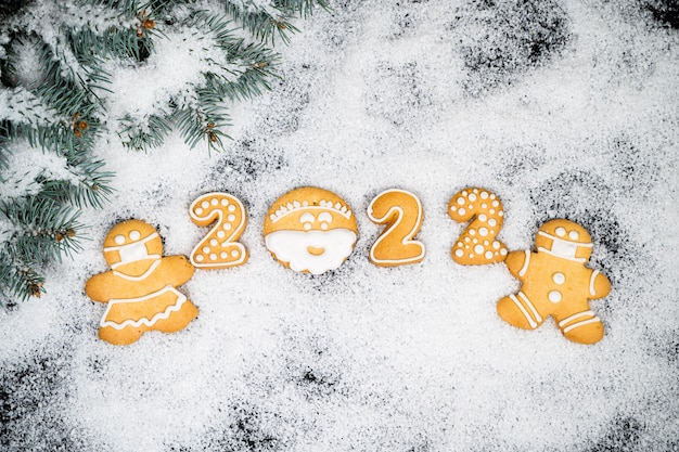 Sfondo di Natale con pan di zenzero sulla neve invernale. Carta d'atmosfera per le vacanze. Vista dall'alto, copia dello spazio. Tradizioni familiari, bricolage, concetto di celebrazione. Sfondo festivo con biscotti di panpepato fatti in casa.