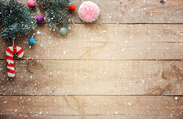 Sfondo di Natale con rami di abete, ornamenti per alberi di Natale in feltro e neve che cade