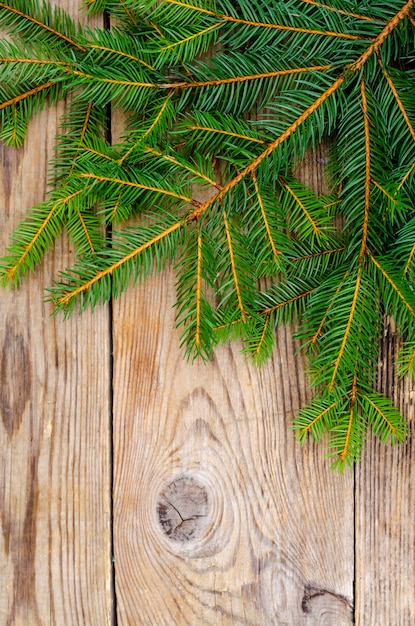 Sfondo di Natale con rami di abete rosso su superficie di legno