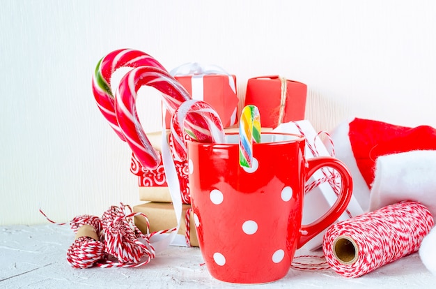 Sfondo di Natale con regali, tazza con bastoncino di zucchero