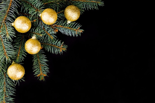 Sfondo di Natale da un ramo di pino con palline d'oro