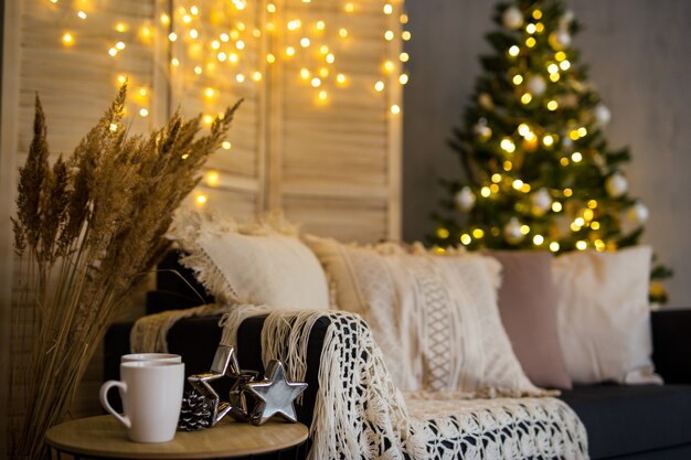 Sfondo di Natale - interni serali accoglienti con albero di Natale decorato e luci ghirlande