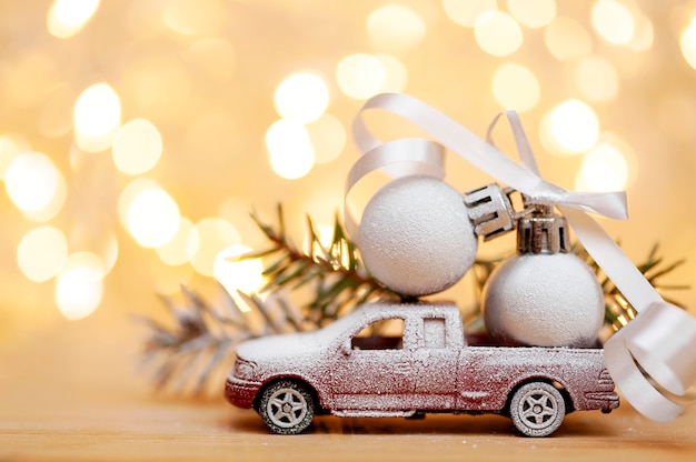 Sfondo di Natale Macchinina coperta di neve con palle di Natale su sfondo bokeh