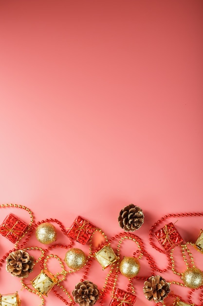 Sfondo di Natale o Capodanno rosa con decorazioni rosse e oro per albero di Natale con spazio libero. La vista dall'alto. Umore del nuovo anno.