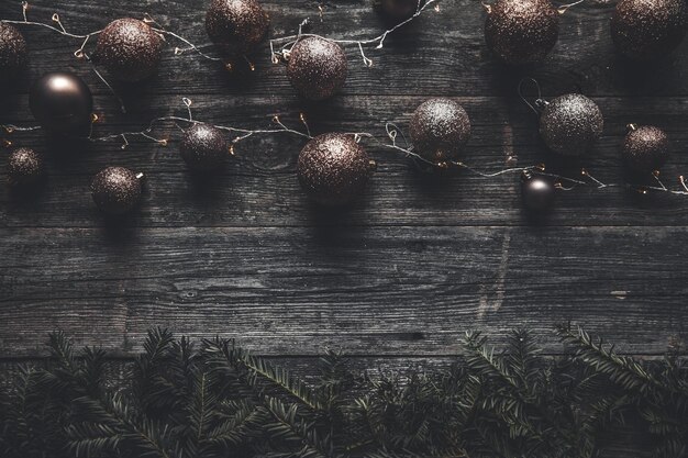 Sfondo di Natale o Capodanno. Vintage albero di Natale decorazione giocattolo palle e ghirlanda di luce su legno rustico sfondo, messa a fuoco selettiva, spazio copia