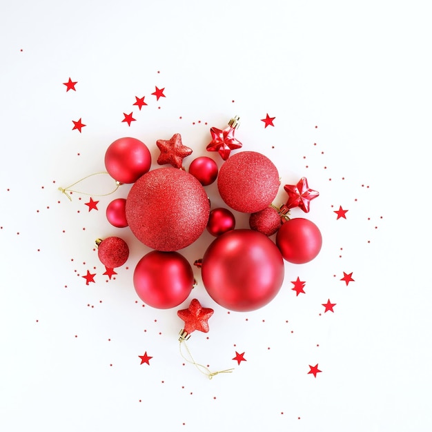 Sfondo di Natale piatto da decorazioni di palline rosse su sfondo bianco