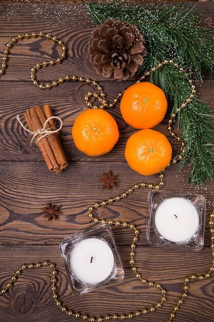 Sfondo di Natale - rami di abete con coni, mandarini con cannella, anice stellato, candele, decorazioni natalizie. Disposizione piatta, spazio vuoto