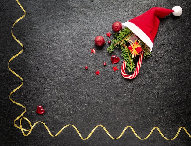 Sfondo di Natale Ramo di abete Decorazioni natalizie regalo di canna al caramello in un cappello di Babbo Natale