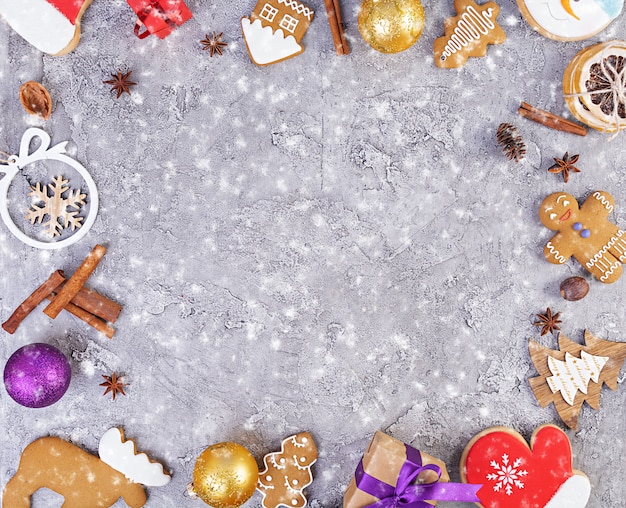 Sfondo di natale. Regalo di Natale, giocattoli, biscotti di panpepato, spezie e decorazioni sul tavolo di legno. Vista dall'alto