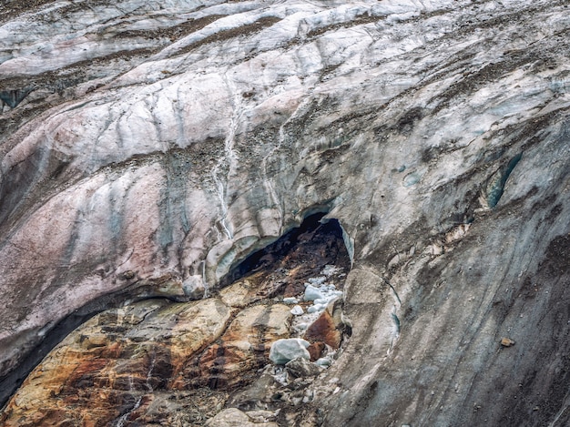 Sfondo di natura minimalista della superficie del ghiacciaio con grandi grotte e crepe. Sfondo naturale minimo di parete ghiacciata e blocchi di ghiaccio dal ghiacciaio da vicino. Bella struttura della natura della parete glaciale scura.