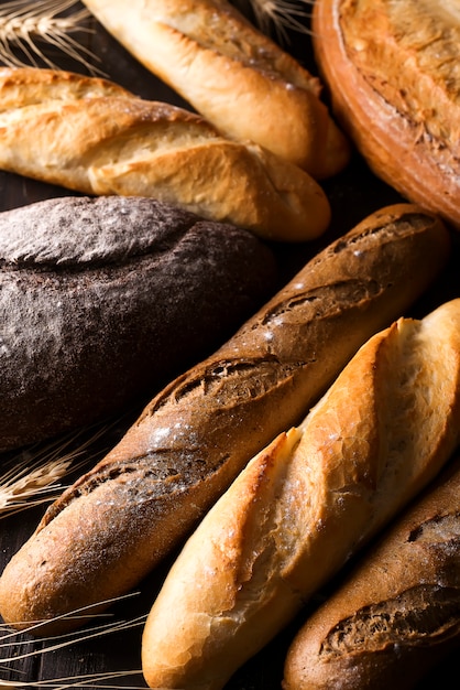 Sfondo di pane fresco al forno, varietà di diversi tipi di pane, industria alimentare