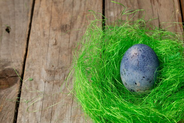 Sfondo di Pasqua con le uova di Pasqua in un nido verde su un tavolo di legno