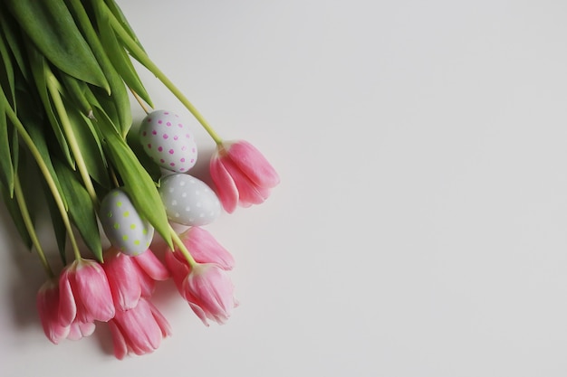 Sfondo di Pasqua con tulipani rosa e uova. Concetto di vacanza di primavera.