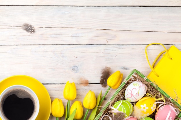 Sfondo di Pasqua con uova colorate e tulipani gialli