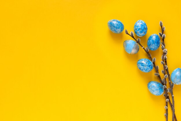 Sfondo di Pasqua con uova di Pasqua blu e fiori primaverili. Vista dall'alto con spazio per il testo.